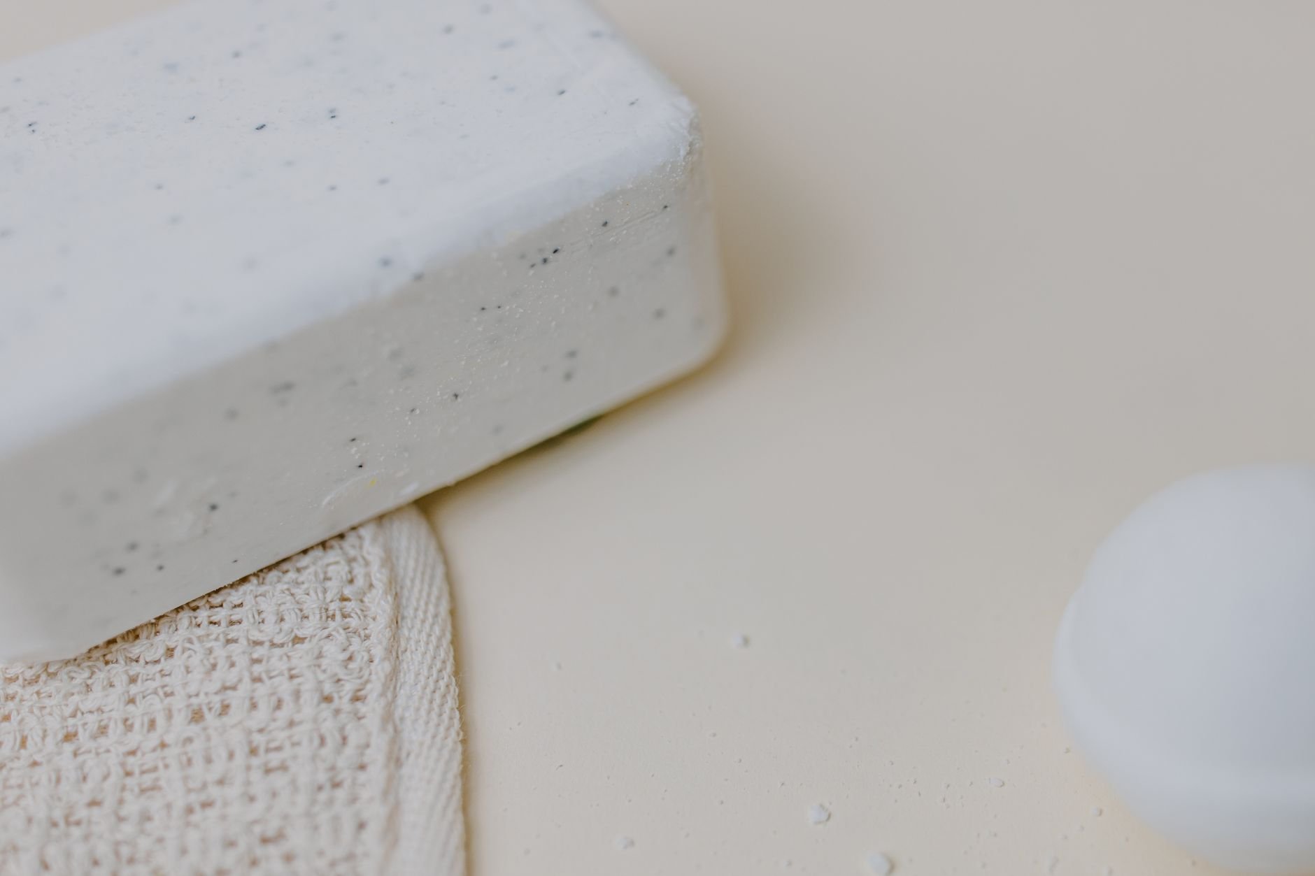 Close-up of a natural handmade bar soap resting on a textured linen cloth